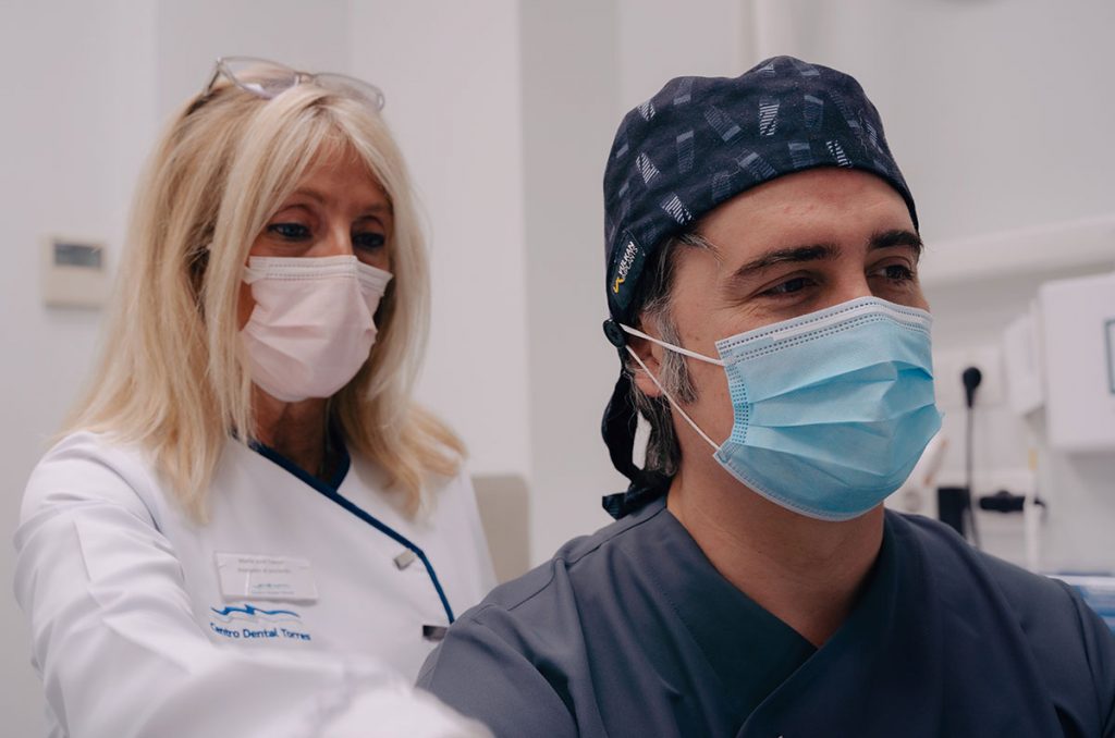 Dos odontólogos de la clínica dental Torres revisando una prueba de un paciente